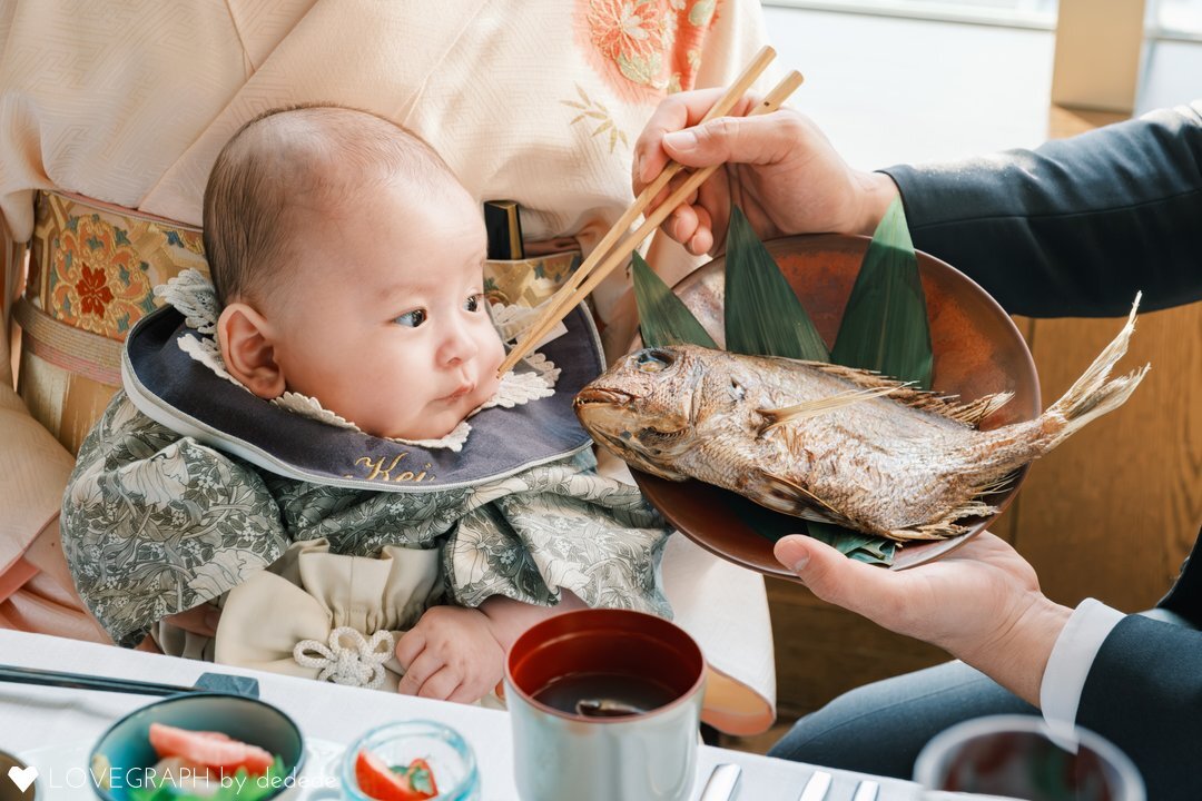 お食い初めにて、口元に箸を運ぶ「食べるまね」の瞬間