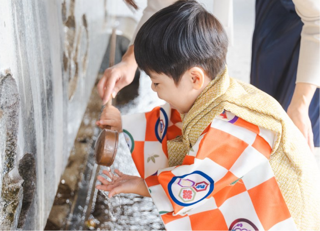 七五三の参拝：神社で手水を使い手を清める、着物姿の3歳の男の子