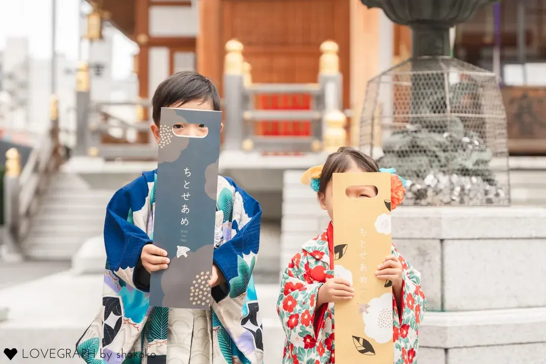 千歳飴を持って笑う七五三の子ども