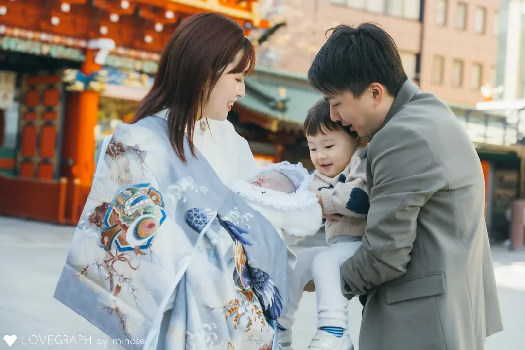 神田明神の随神門を背景に祝い着姿の赤ちゃんを抱く家族