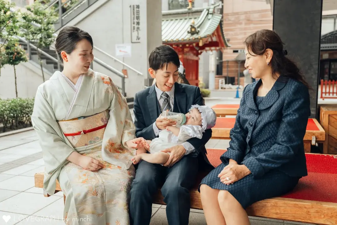 神田明神のお宮参りで赤ちゃんを囲んで微笑む家族