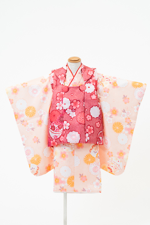 七五三(三歳) | 淡いオレンジ地に咲き誇る花々と手毬×赤(柄)の被布