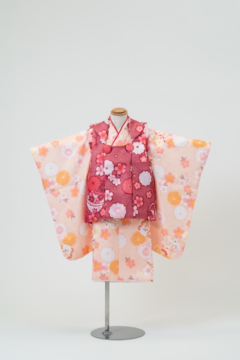 七五三(三歳) | 淡いオレンジ地に咲き誇る花々と手毬×赤(柄)の被布